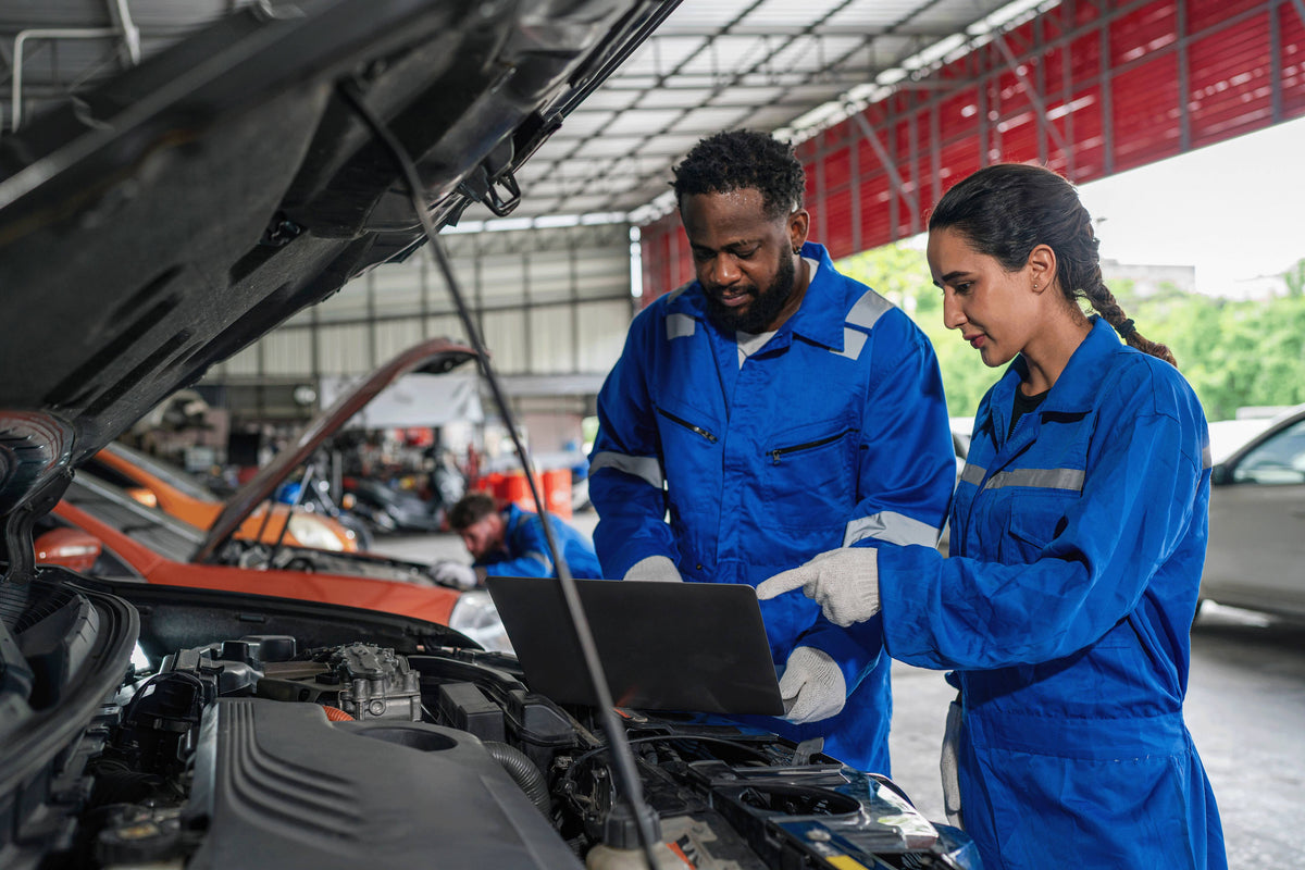 Mechanics Diagnosing Vehicle in Engine Bay